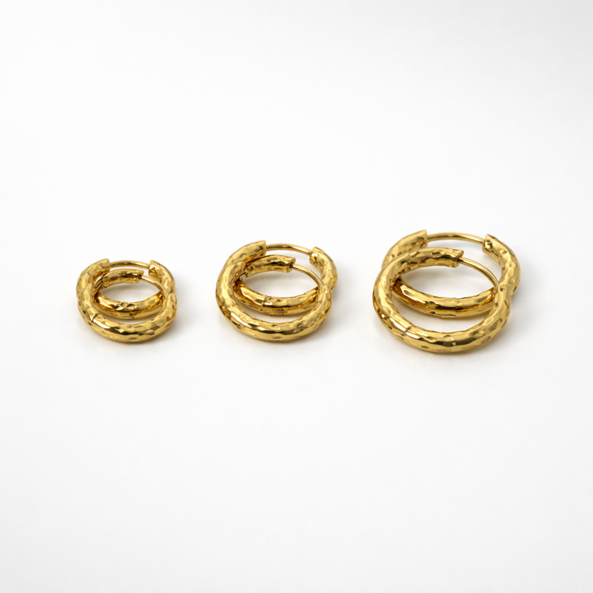Three pairs of gold hoop earrings side by side, in size 8mm, 10mm and 12mm on a white background