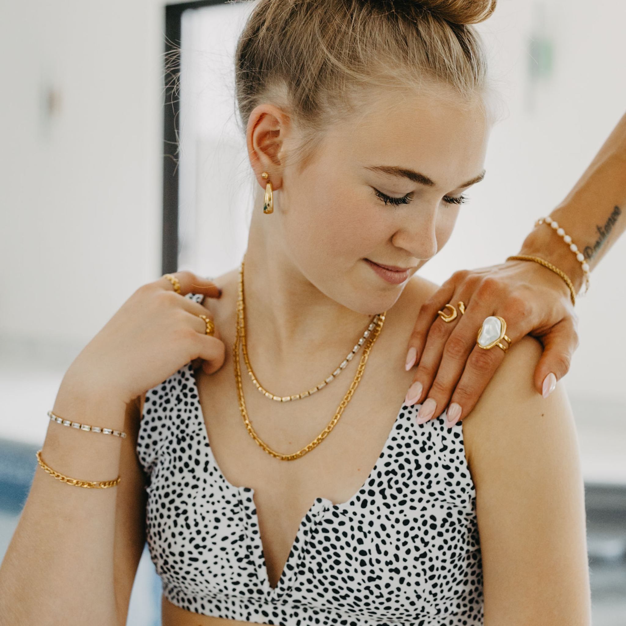 model wearing Forge figaro chain necklace and bracelet layered with gold jewelry in waterproof 18K gold PVD