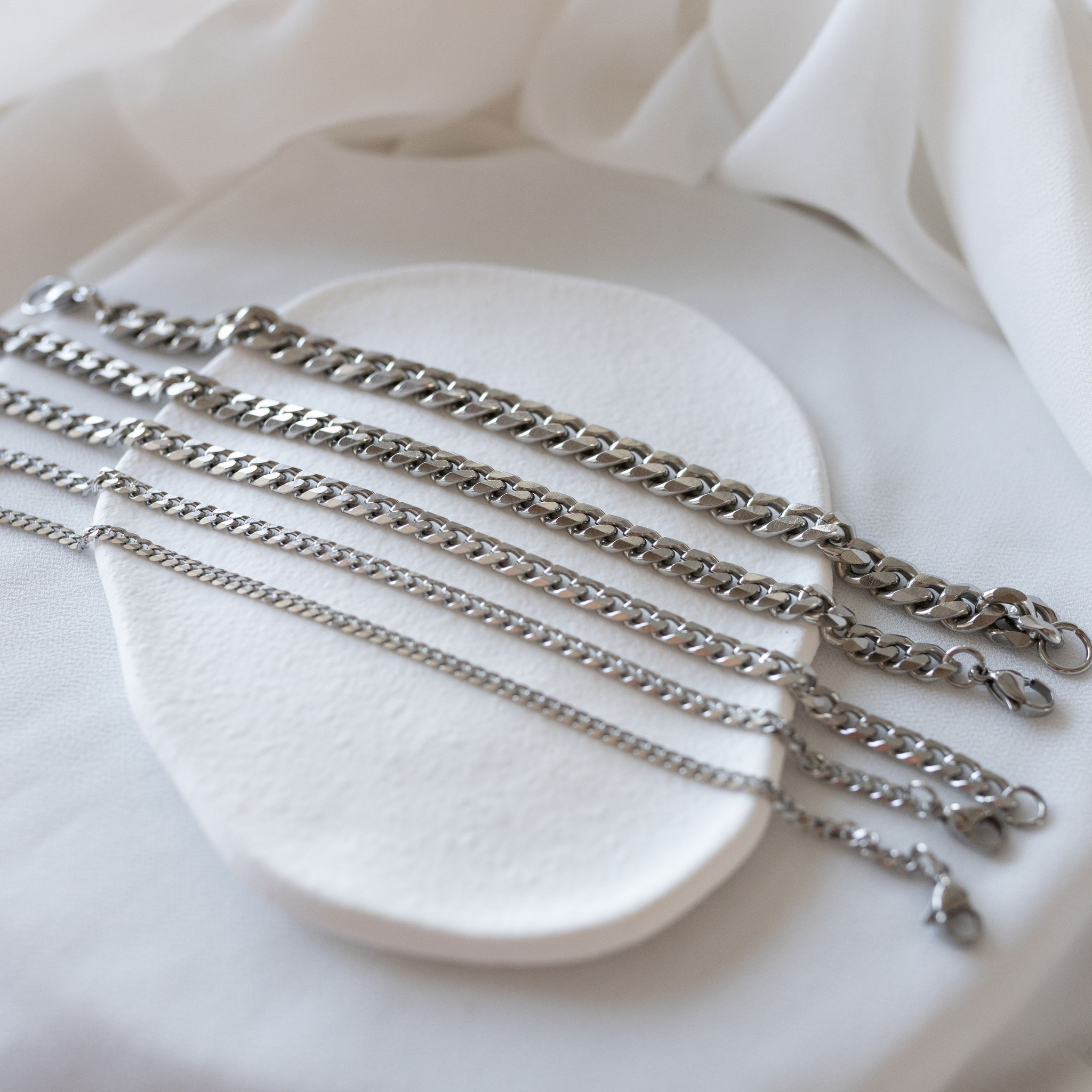 Sunseeker silver Cuban link bracelets in stainless steel displayed in multiple widths waterproof jewelry