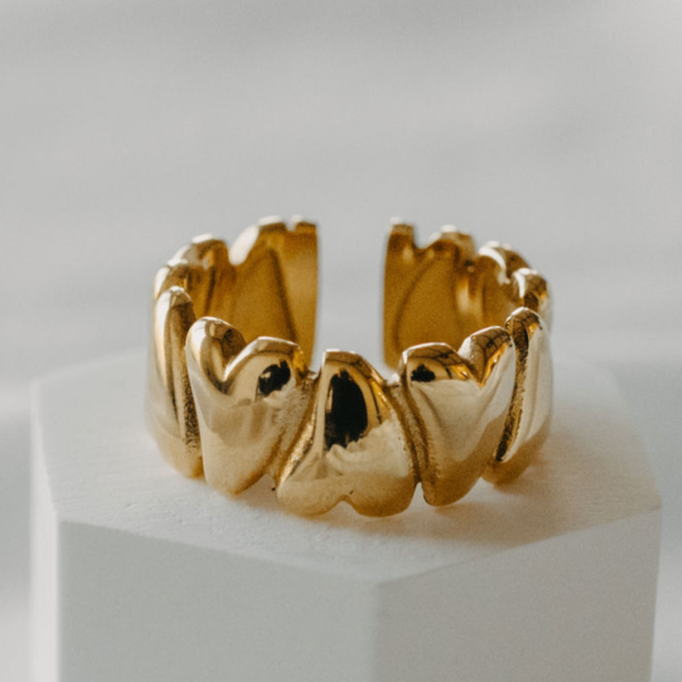 Adjustable waterproof 18K gold PVD heart ring on white pedestal