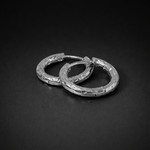 Close up of the silver  waterproof Aura Hoops, size 12mm, on a black surface 6