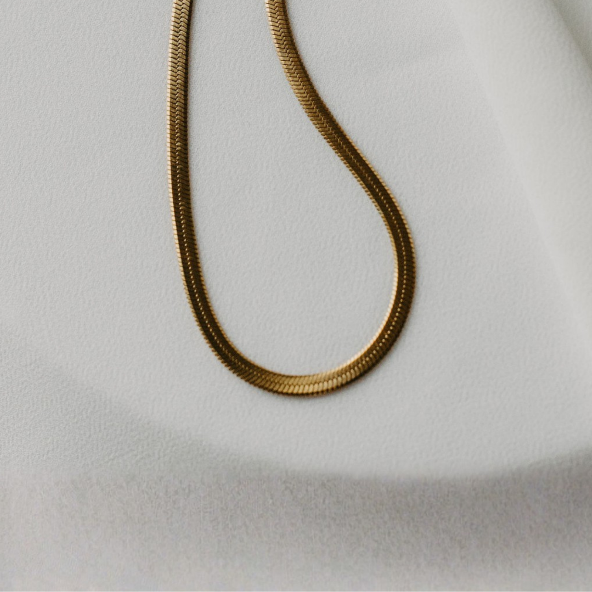 Eclipse herringbone necklace in 18K gold PVD showing flat chain texture and high shine finish
