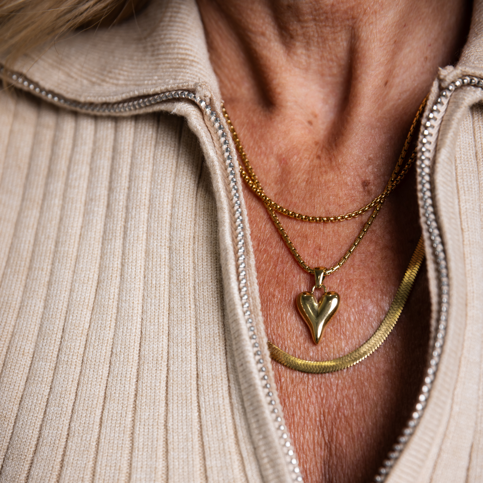 Eclipse herringbone necklace layered with gold heart pendant necklace in waterproof 18K gold PVD jewelry