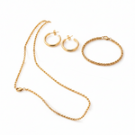 Essential Set jewelry featuring 18K gold PVD waterproof necklace, bracelet and hoop earrings displayed on soft pink blocks, tarnish resistant gold jewelry set 1