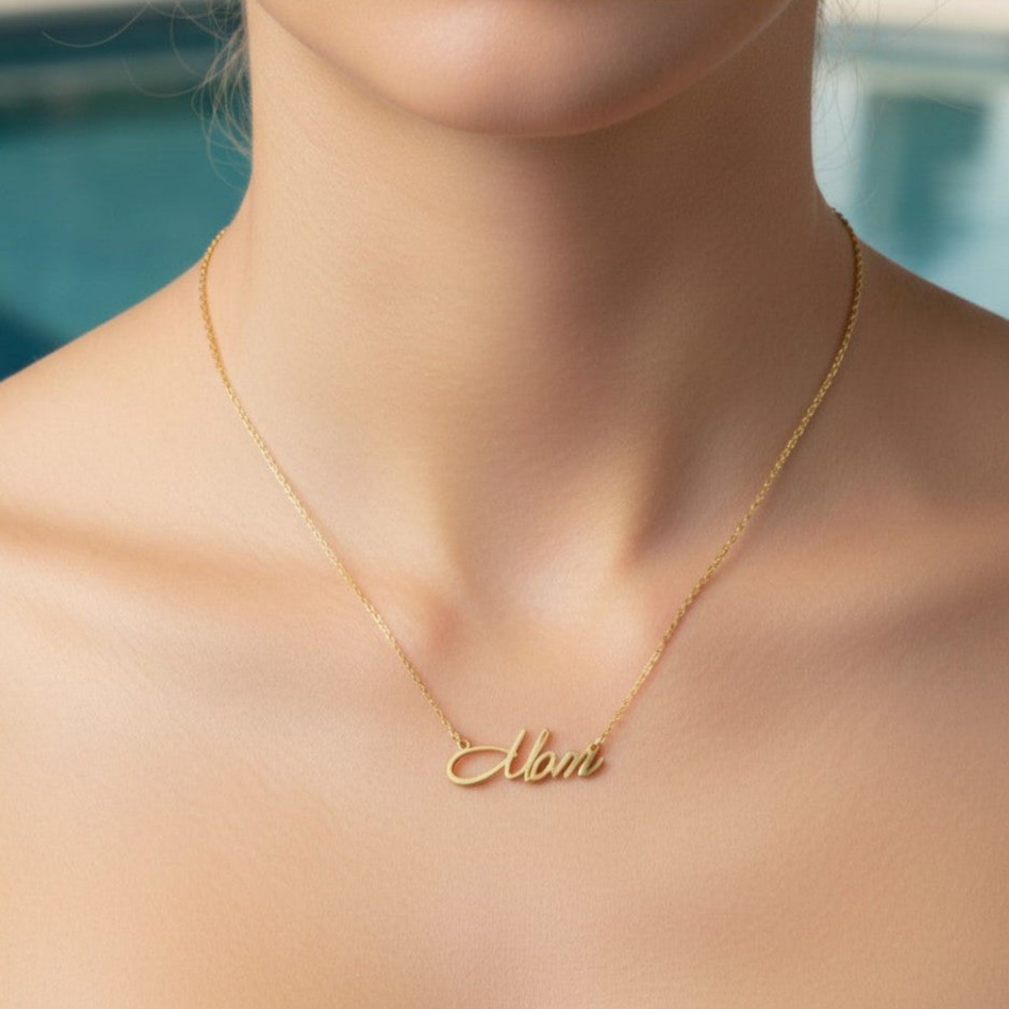 woman wearing signature script mom necklace in gold PVD on fine chain, minimal neckline lifestyle image