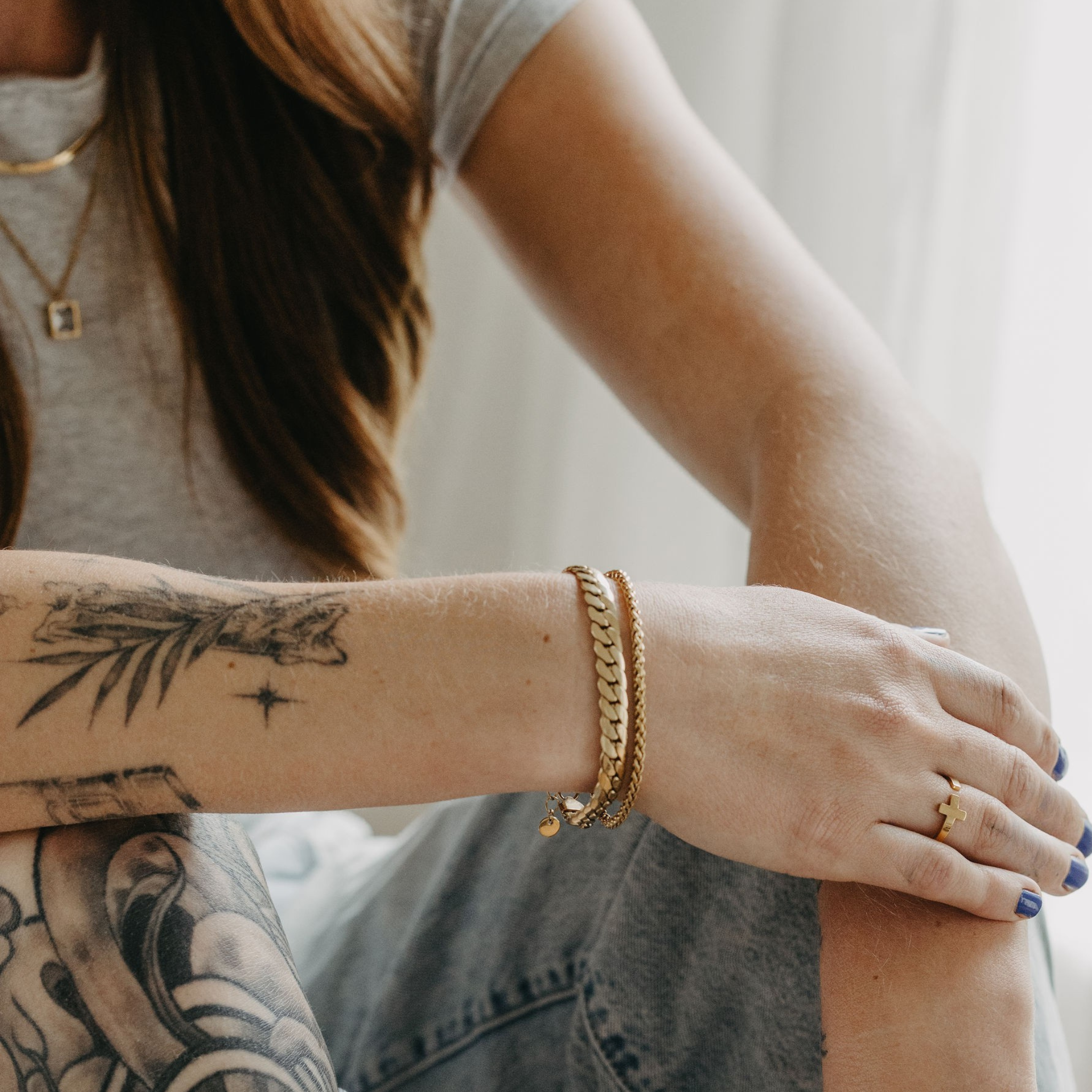 model wearing Surfside 3mm wheat chain bracelet in 18K gold PVD with everyday layered jewelry